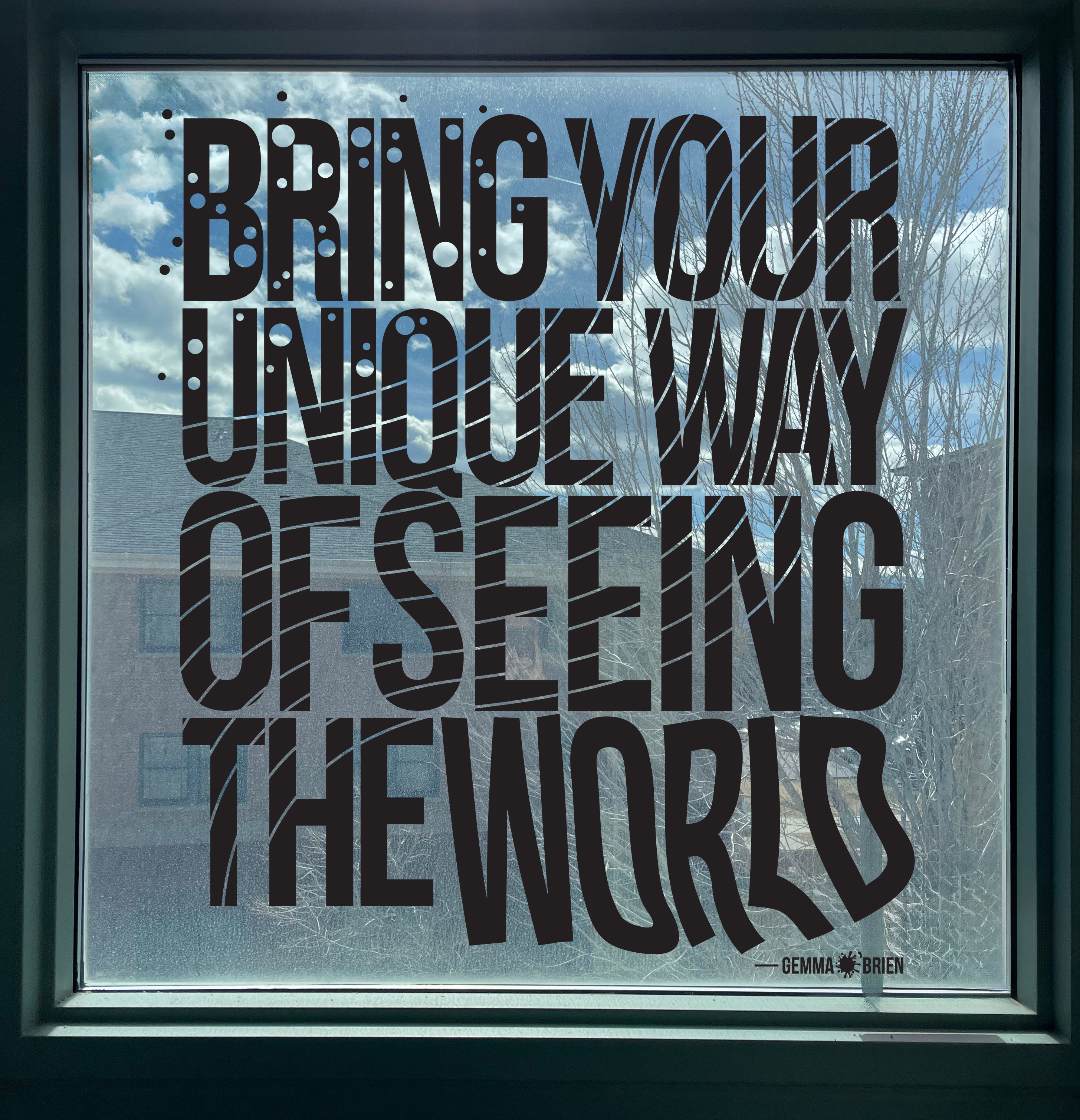 Window withe a black vinyl sticker on it that reads: "Bring your unique way of seeing the world -Gemma O'Brien"